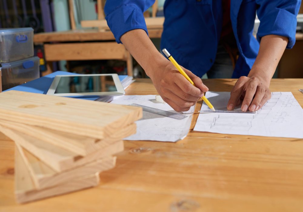 Cropped image of carpenter drawing a furniture piece