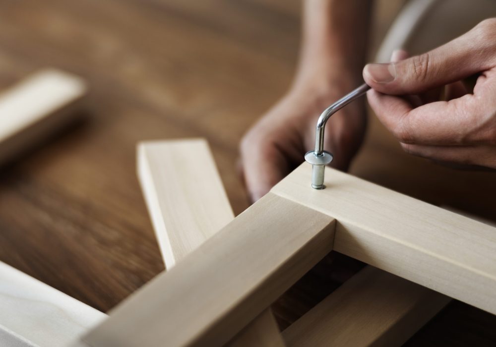 Woman screwing in chair’s nail for ready-to-assemble furniture